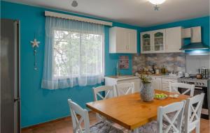 una cucina con pareti blu e tavolo e sedie in legno di Awesome Home In Smokvica With Wifi a Smokvica