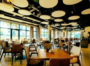 a restaurant with tables and chairs and large windows at Laurasapartment in Jarosławiec