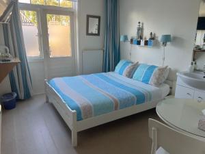 a small bedroom with a bed and a sink at B&B de Zandtaart in Egmond aan Zee