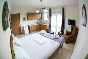 1 dormitorio con 1 cama blanca grande y cocina en Agrelia en Agreliá
