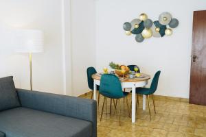 a dining room with a table with chairs and a couch at Host Wise - Sweet & Sunny Flat - Ace Location in Quarteira