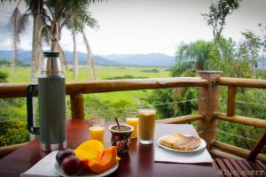 una mesa con platos de comida y zumo de naranja en Residencial Paraíso da Gamboa en Garopaba