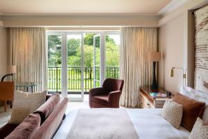 ein Hotelzimmer mit einem Bett und einem Balkon in der Unterkunft The Grove in Chandler's Cross