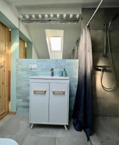 een badkamer met een wastafel en een douche bij Brezno Apartament in Gdańsk