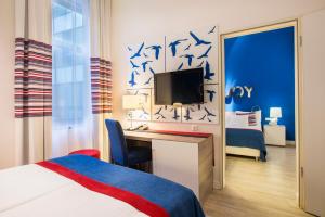 a hotel room with a bed and a desk with a tv at Estilo Fashion Hotel Budapest in Budapest +48 photos