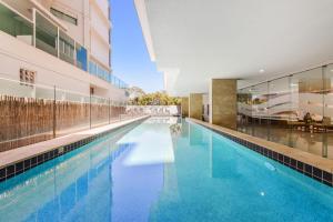 una piscina en medio de un edificio en Redvue Holiday Apartments, en Redcliffe