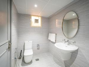 a bathroom with a sink and a toilet and a mirror at Soft touch & Spacious 2 Bed next to Metro in Dubai