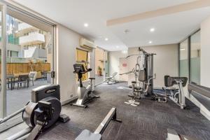 a gym with treadmills and machines in a building at Redvue Holiday Apartments in Redcliffe