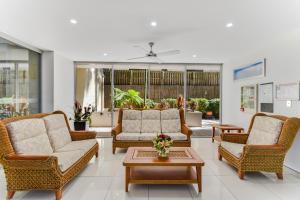 a living room with two couches and a table at Redvue Holiday Apartments in Redcliffe