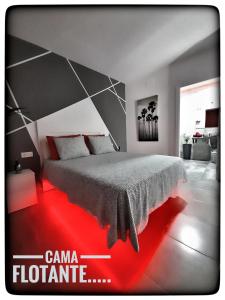 1 dormitorio con 1 cama grande y suelo rojo en Sirocco, en Chiclana de la Frontera