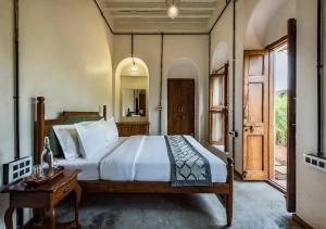 a bedroom with a large bed and a mirror at SaffronStays Amolee, Alibaug in Alibaug