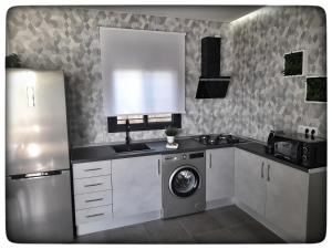 una cocina con lavadora y nevera en Sirocco, en Chiclana de la Frontera