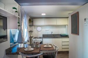 a small kitchen with a table and chairs in it at Residencial Paraíso da Gamboa in Garopaba +20 photos
