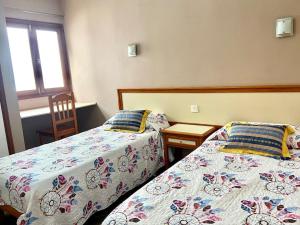 1 Schlafzimmer mit 2 Betten, einem Tisch und einem Fenster in der Unterkunft Apartamento vista mar en Flamboyan - San Agustín in San Bartolomé de Tirajana