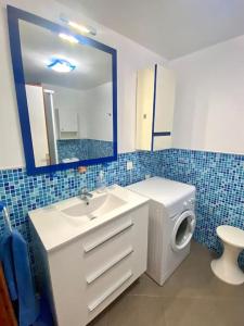 a bathroom with a sink and a toilet and a mirror at Apartamento vista mar en Flamboyan - San Agustín in San Bartolomé de Tirajana
