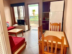 una cucina e un soggiorno con tavolo e frigorifero di Apartamento vista mar en Flamboyan - San Agustín a San Bartolomé