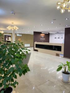 a lobby with plants and a large screen in a building at Chagala Hotel Uralsk in Oral