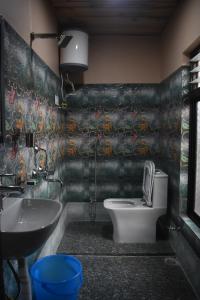 La salle de bains est pourvue de toilettes et d'un lavabo. dans l'établissement Hidden Cottage, à Namchi