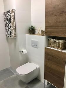a white bathroom with a toilet and a towel at New apartment in Słupsk Downtown /Parking in Słupsk