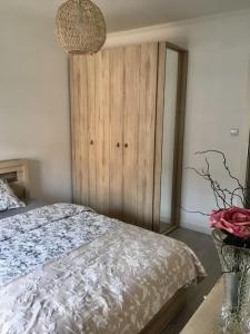a bedroom with a bed and a vase with flowers at New apartment in Słupsk Downtown /Parking in Słupsk