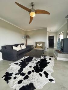 a living room with a cow patterned rug at Living The Breede - Inhoek Farm Gatehouse in Malgas +19 photos