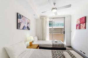 a bedroom with two beds and a window at Redvue Holiday Apartments in Redcliffe