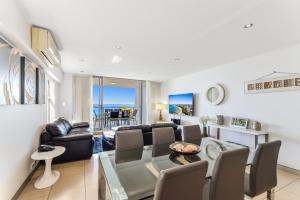 a living room with a table and chairs and a couch at Redvue Holiday Apartments in Redcliffe
