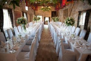 a row of tables in a room with white chairs at Spread Eagle Hotel And Spa in Midhurst