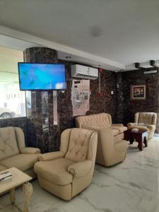 een woonkamer met banken en een flatscreen-tv bij شقق العنوان للوحدات المخدومة ALanwaan apartments for serviced units in Dammam