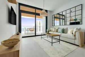 un salon avec un canapé et une table dans l'établissement SUNSET WAVES fresh apartments, à Benidorm