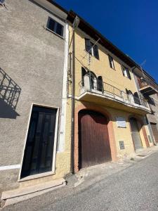 a building with a large door and a balcony at La casa di Peppe e Lucia in Poggio Bustone