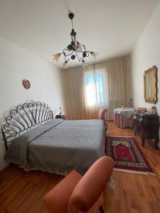 a bedroom with a large bed with a chandelier at La casa di Peppe e Lucia in Poggio Bustone