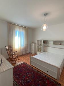 a bedroom with a bed and a chair and a rug at La casa di Peppe e Lucia in Poggio Bustone