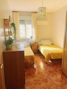 a room with two beds and a window at El Apartamento de Trini in Seville