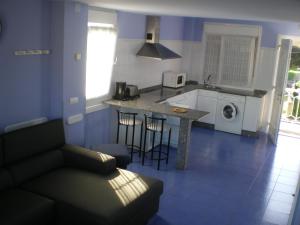 a living room with a couch and a kitchen at BAÑUGUES TURISMO S.L. in Bañugues