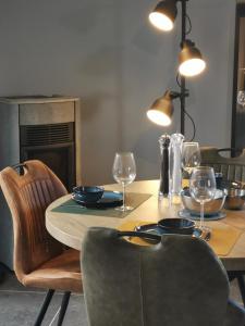 mesa de comedor con sillas y mesa con copas de vino en Le Rougegorge, en Framont