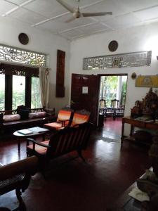 a living room with couches and tables and windows at Traditional Kandyan House in Kandy