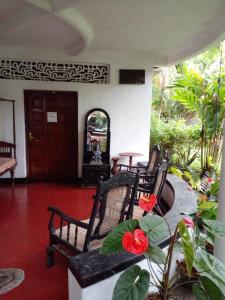 - une terrasse couverte avec des chaises, une table et une porte dans l'établissement Traditional Kandyan House, à Kandy