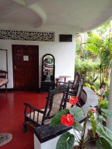 a porch with chairs and a table and a door at Traditional Kandyan House in Kandy