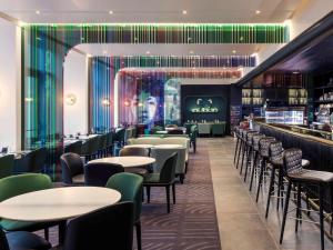 a restaurant with tables and chairs and a bar at Mercure Paris Boulogne in Boulogne-Billancourt