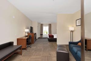 a hotel room with a couch and a bed at Comfort Suites University in Abilene