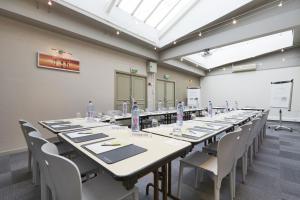 a large room with a long table with chairs and a whiteboard at Campanile Paris Ouest - Porte de Champerret Levallois in Levallois-Perret