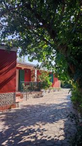 budynek z czerwoną ścianą i drzewem w obiekcie La Villa Franca Pompeii w mieście Pompeje