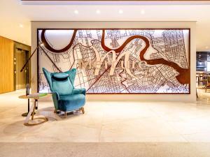 a lobby with a chair and a large painting at Mercure Itajai Navegantes in Itajaí