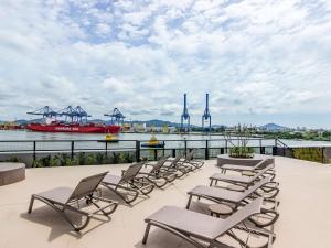 a group of chairs sitting on a balcony overlooking a river at Mercure Itajai Navegantes in Itajaí