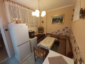 ein Wohnzimmer mit einem Kühlschrank und einem Tisch in der Unterkunft Vár-lak Vendégház in Szendrő