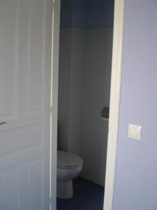 baño con aseo y puerta blanca en BAÑUGUES TURISMO S.L., en Bañugues