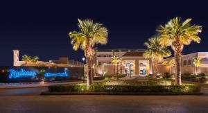 ośrodek z palmami przed budynkiem w obiekcie Radisson Hotel Riyadh Airport w Rijadzie