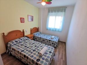 1 Schlafzimmer mit 2 Betten und einem Deckenventilator in der Unterkunft Apartamento Mar de Oropesa ll in Oropesa del Mar