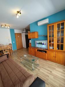 ein Wohnzimmer mit einem Sofa und einem TV in der Unterkunft Apartamento Mar de Oropesa ll in Oropesa del Mar